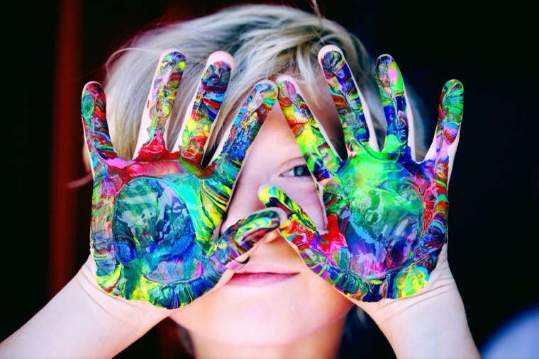 Des mains d'enfant couvertes de peinture, en atelier